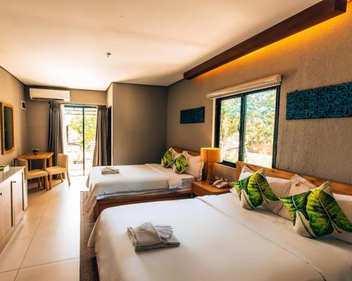 a hotel room with two beds and a window at Pearl Vista de Coron Resort Hotel in Coron