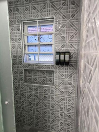 a bathroom with a window and a tiled wall at Soleil Paradise Palms in Priory