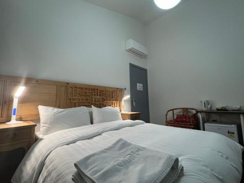 a bedroom with a large white bed with a wooden headboard at Sinofield Edu-Retreat in Leura