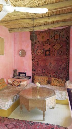 a room with two beds and a table in it at Auberge Chez Julia in Merzouga