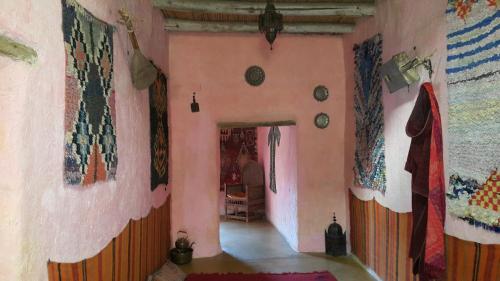 a room with paintings on the walls of a house at Auberge Chez Julia in Merzouga