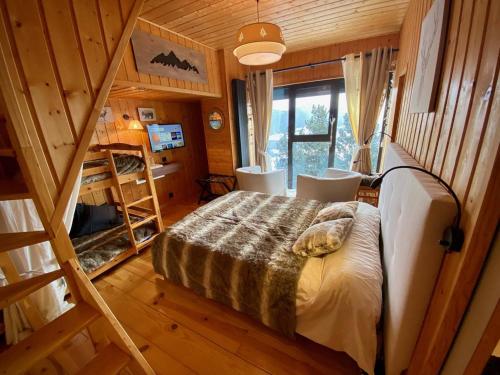una camera con un letto in una stanza con una scala di Chalet chaleureux avec jacuzzi, parking et Wi-Fi aux Angles - FR-1-593-121 a Les Angles
