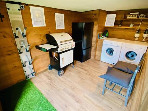 une cuisine avec une cuisinière et une machine à laver dans l'établissement Chalet chaleureux avec jacuzzi, parking et Wi-Fi aux Angles - FR-1-593-121, aux Angles