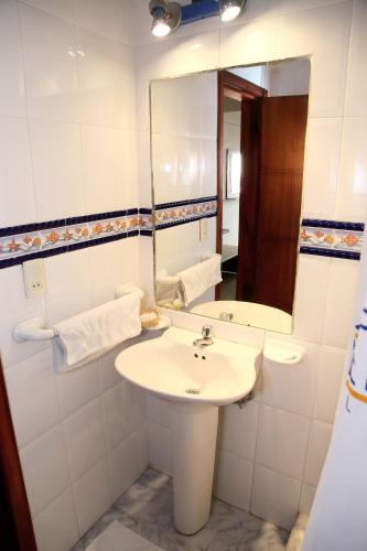 a bathroom with a sink and a mirror at Hotel Puerto Ballesta in Tonsupa