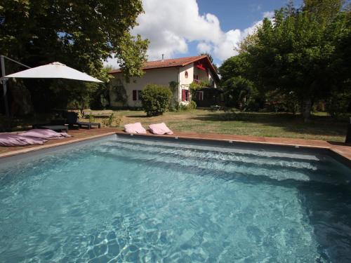 einen Pool vor einem Haus mit Sonnenschirm in der Unterkunft Maison spacieuse près du lac avec piscine privée, idéal pour 16 personnes - FR-1-50-145 in Aureilhan