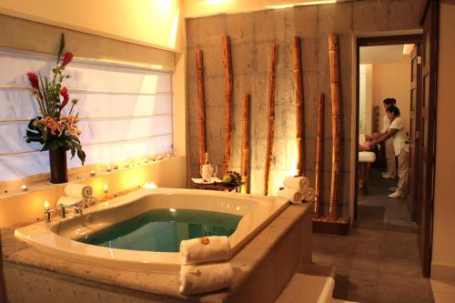 een badkamer met een bad met een persoon in de deuropening bij Sunscape Sabor Cozumel in Cozumel