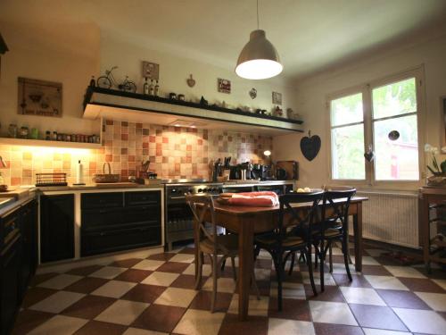 une cuisine avec une table et quelques chaises dans l'établissement Maison spacieuse près du lac avec piscine privée, idéal pour 16 personnes - FR-1-50-145, à Aureilhan