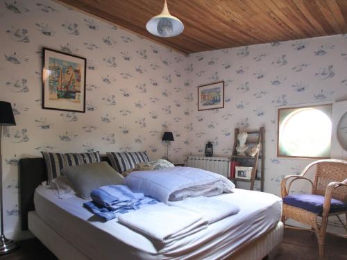 ein Schlafzimmer mit einem Bett in einem Zimmer mit Tapete in der Unterkunft Maison spacieuse près du lac avec piscine privée, idéal pour 16 personnes - FR-1-50-145 in Aureilhan