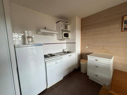 Elle comprend une petite cuisine équipée d'un réfrigérateur blanc et d'un évier. dans l'établissement Appartement 3 pièces au calme avec parking - FR-1-593-120, aux Angles