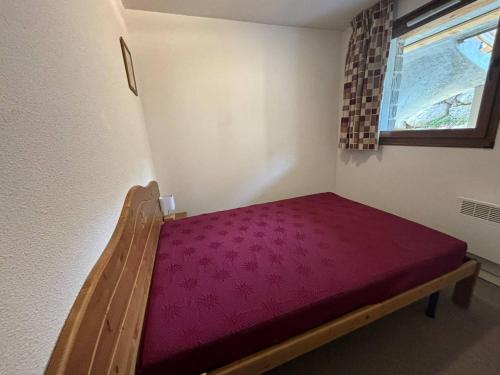 Ce petit lit se trouve dans un dortoir doté d'un matelas rouge. dans l'établissement Appartement 3 pièces au calme avec parking - FR-1-593-120, aux Angles