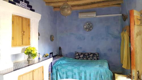 a bedroom with a bed in a blue room at Auberge Chez Julia in Merzouga