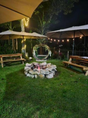 a fire pit in a yard with two benches and an umbrella at Alto Quiel Country in Alto Quiel