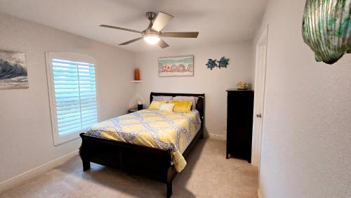 a bedroom with a bed and a ceiling fan at The Cape - Four Bedroom in Cape Coral