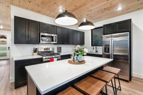 a kitchen with black cabinets and a white counter top at New Luxurious 4Bd 5B Ensuite Cabin with Indoor Pool, HotTub, Theater and Game Room, Spring Deal in Sevierville