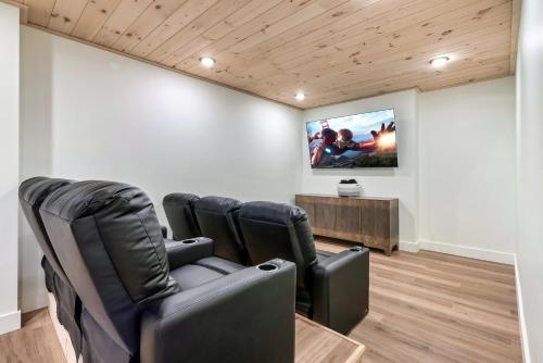 a waiting room with black chairs and a flat screen tv at New Luxurious 4Bd 5B Ensuite Cabin with Indoor Pool, HotTub, Theater and Game Room, Spring Deal in Sevierville