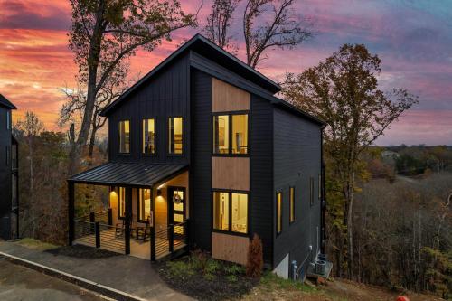 a black house with the sunset in the background at New Luxurious 4Bd 5B Ensuite Cabin with Indoor Pool, HotTub, Theater and Game Room, Spring Deal in Sevierville