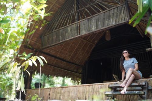 a woman sitting on the edge of a building at KRABI BAMBOO KINGDOM at AOLUEK PARADISE in Ao Luk