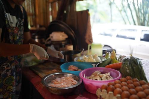 a person preparing food on a table with bowls of food at KRABI BAMBOO KINGDOM at AOLUEK PARADISE in Ao Luk