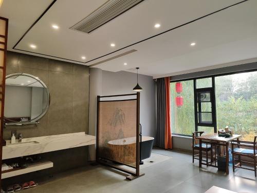 洛阳Qichi Waterfront B&B Hotel的带浴缸、水槽和桌子的浴室