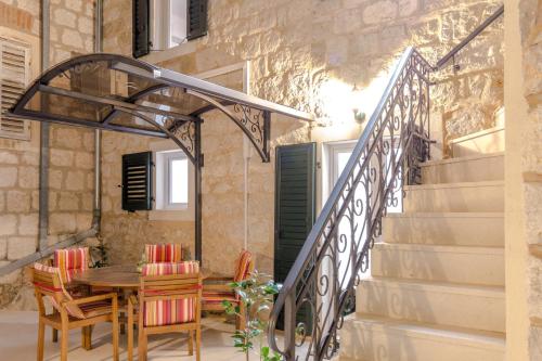 a patio with a table and chairs and stairs at Apartments and Rooms Villa Erede in Split