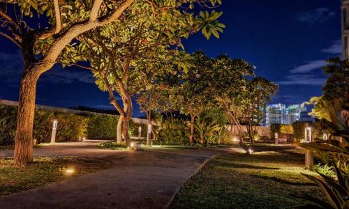 a park with trees and lights at night at The French Apartment Pasig - Fast Wi-Fi and pool in Manila