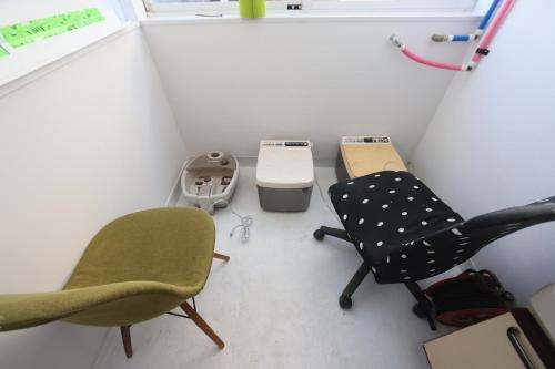 a room with two chairs and a trash can at Mount Fuji Omotenashi Guesthouse in Fujinomiya