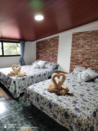 a room with two beds with towel animals on them at Alto Quiel Country in Alto Quiel