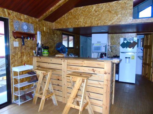 a kitchen with a counter with stools and a refrigerator at Alto Quiel Country in Alto Quiel