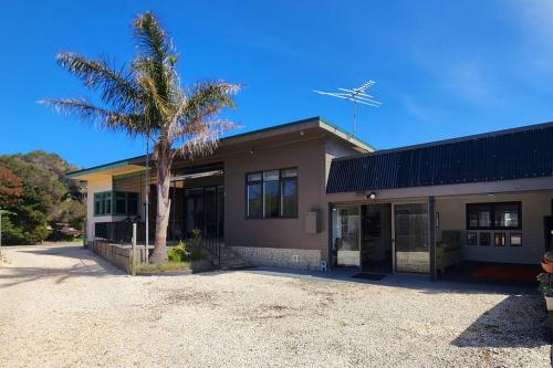 a building with a palm tree in front of it at Rosebud Retro Retreat in Rosebud