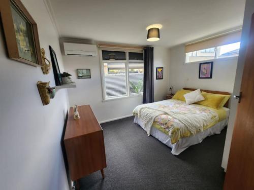 a bedroom with a bed and a desk and a window at Rosebud Retro Retreat in Rosebud
