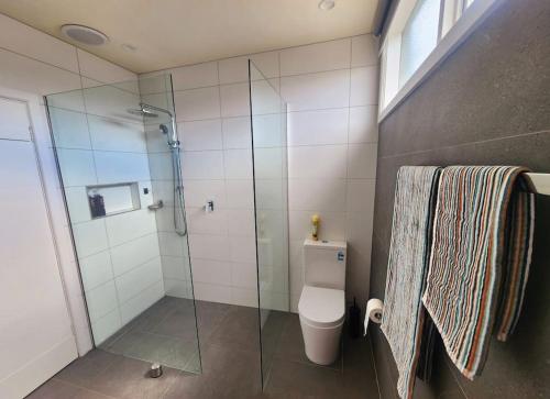 a bathroom with a glass shower and a toilet at Rosebud Retro Retreat in Rosebud
