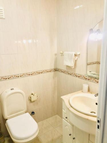 a white bathroom with a toilet and a sink at Cantinho de Algés in Algés