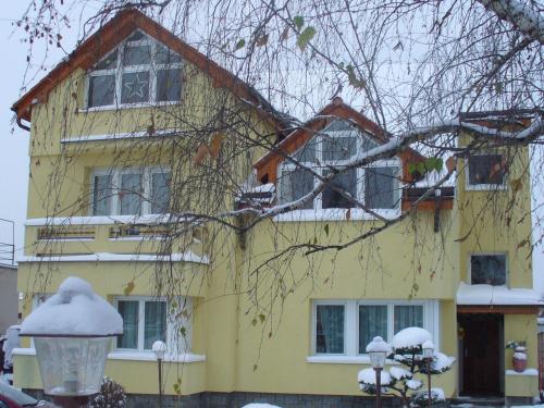 une maison jaune recouverte de neige dans l'établissement Fontána, à Prague