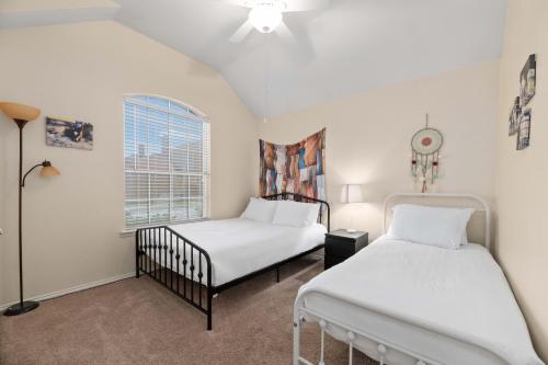 a bedroom with two beds and a window at Relaxing 3BR 2BA Oasis - Hot Tub & 5 Beds! in The Colony