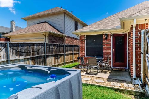 a backyard with a hot tub in front of a house at Relaxing 3BR 2BA Oasis - Hot Tub & 5 Beds! in The Colony