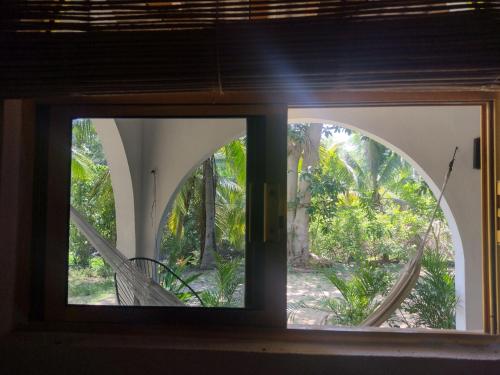 an open window with a view of a garden at Casa pájaros- Habitacion Quetzal in Troncones