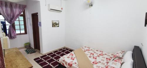a living room with a couch with pillows on it at Anggerik Homestay in Kampong Batang Melekek