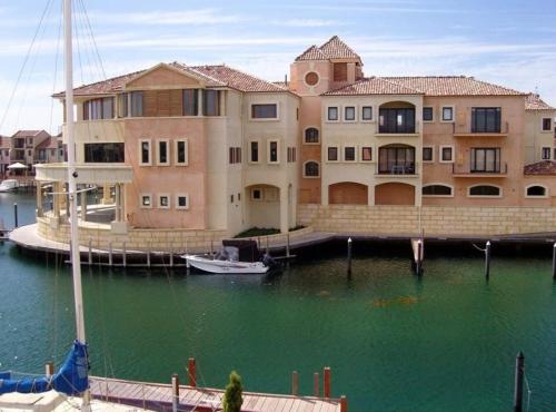 a large building with a boat in the water at Venice On The Beach Family Waterfront Escape in Wannanup