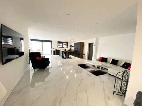 a large white living room with a couch and chair at Villa Princesse neuve & grand standing ! in Valmont