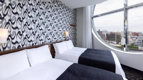 Postel nebo postele na pokoji v ubytování APA Hotel Nihonbashi Hamacho Ekiminami
