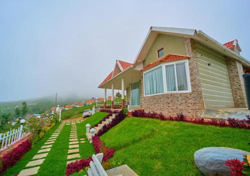a house on a hill with flowers in the yard at EMYs Misty Charm Private Villa Ooty by VOYE HOMES in Ooty