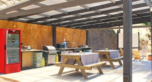 an outdoor kitchen with two tables and a red refrigerator at Glamping de Matanzas in Matanzas