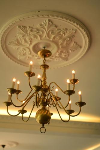 a chandelier with candles hanging from a ceiling at Agbo Hotel in Polonnaruwa