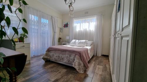 a bedroom with a bed with white pillows on it at Bird Song in Cape Town