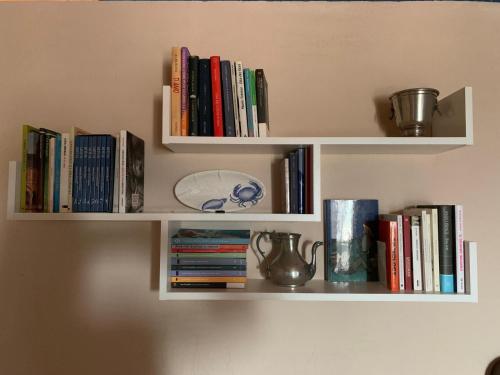 a white book shelf with books on it at La casa delle stelle in Tirli