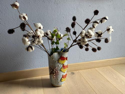 a vase with flowers in it sitting on a table at La casa delle stelle in Tirli