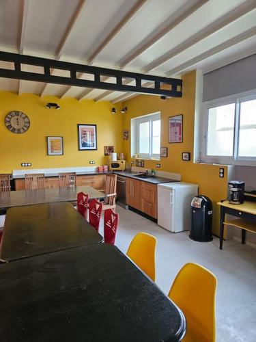 une cuisine avec une table et des chaises dans une pièce dans l'établissement La salle de jeux, à Saint-Lubin-en-Vergonnois