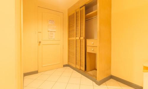 a kitchen with a closet with a door and a tiled floor at Royal Am Rei Hotel by RedDoorz in Bacolod