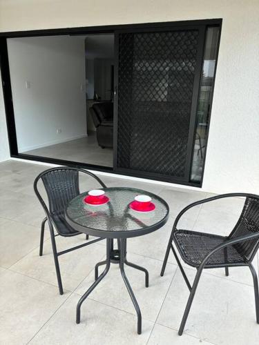 two chairs and a glass table with two chairs at Family size tropical oasis retreat netflix wifi in Redlynch