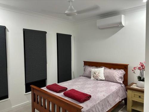 a bedroom with a bed with two red pillows on it at Family size tropical oasis retreat netflix wifi in Redlynch